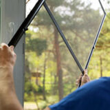 man installing mosquito net wire mesh on house window